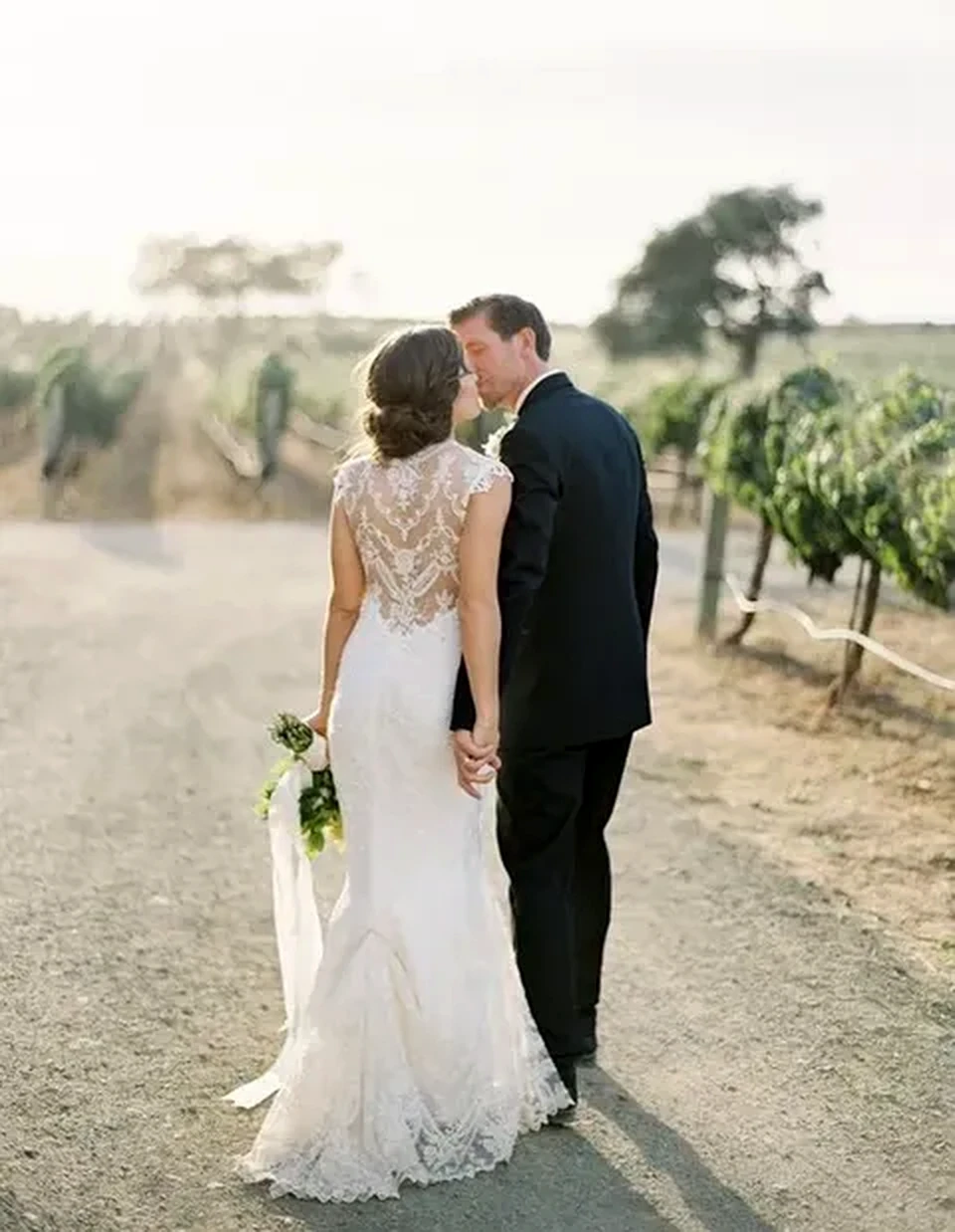 Bride showing the detailed back of an elegant lace wedding dress